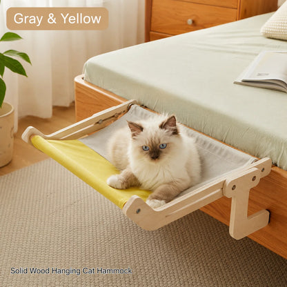Gray and yellow wooden cat hammock attached to a bed frame with cat lounging